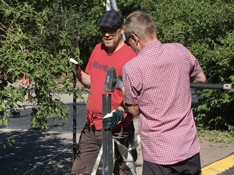 Kuvasssa lastenfestivaali Seikkisrockin kaksi vapaaehtoistyöntekijää rakentamassa aitaa